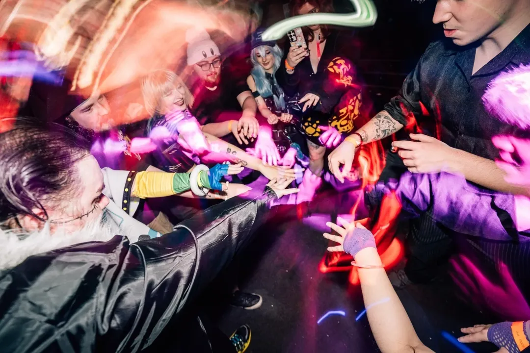 Friends putting their hands together at an anime event