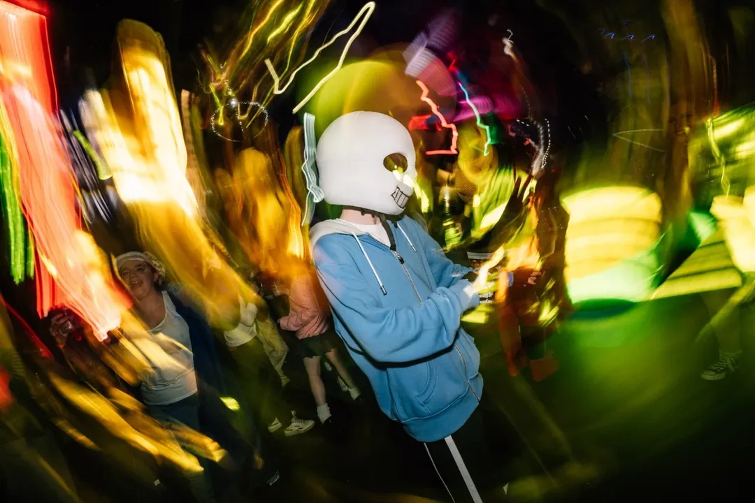 Cosplayer moving through colourful club lights